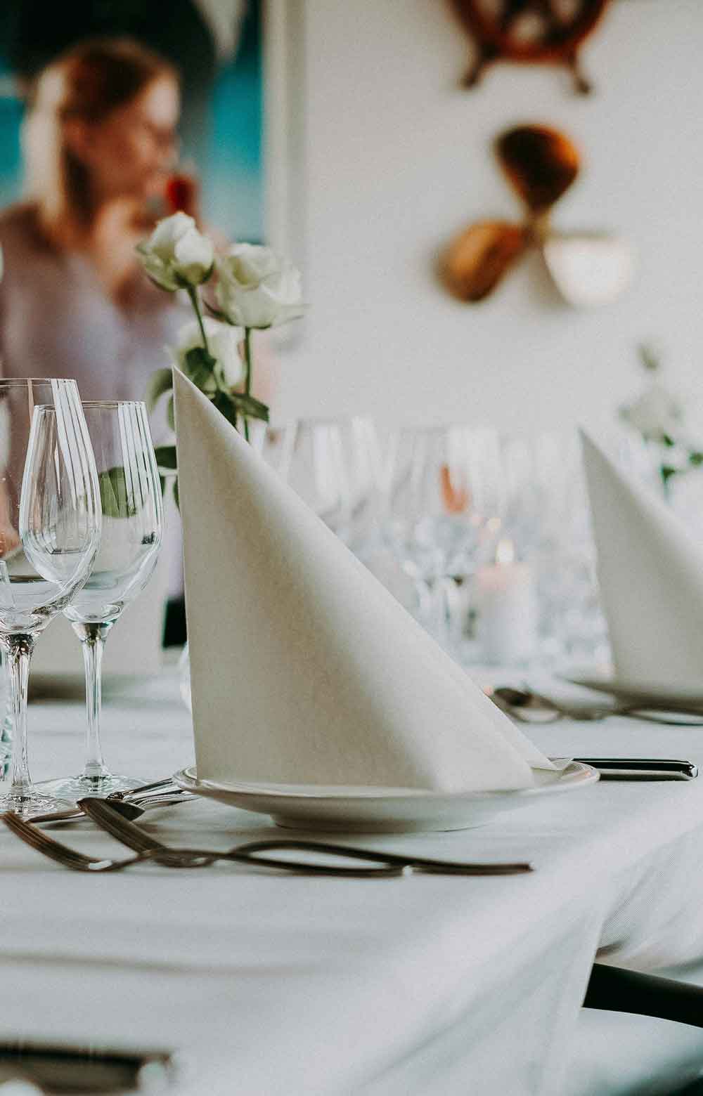Mesa de restaurante con servilleta de tela doblada en triángulo
